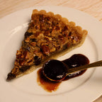 Slice of pecan pie with a spoonful of organic Rebel Thumb jam made in California