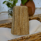 Sustainable and eco-friendly natural loofah (luffa) sponge with a string on a white surface 